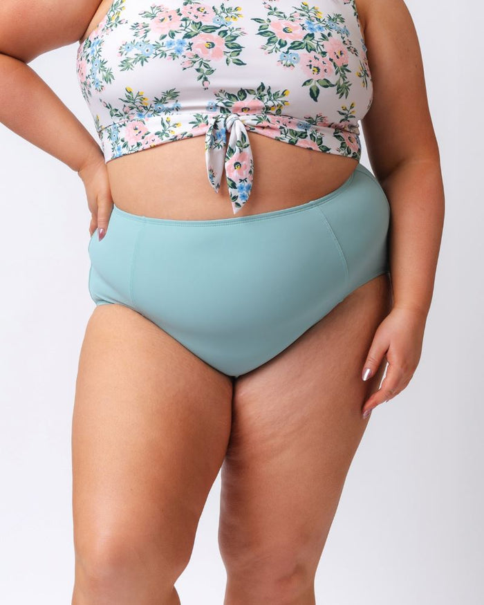 Close up photo of a woman wearing a light blue high waist swim bottom