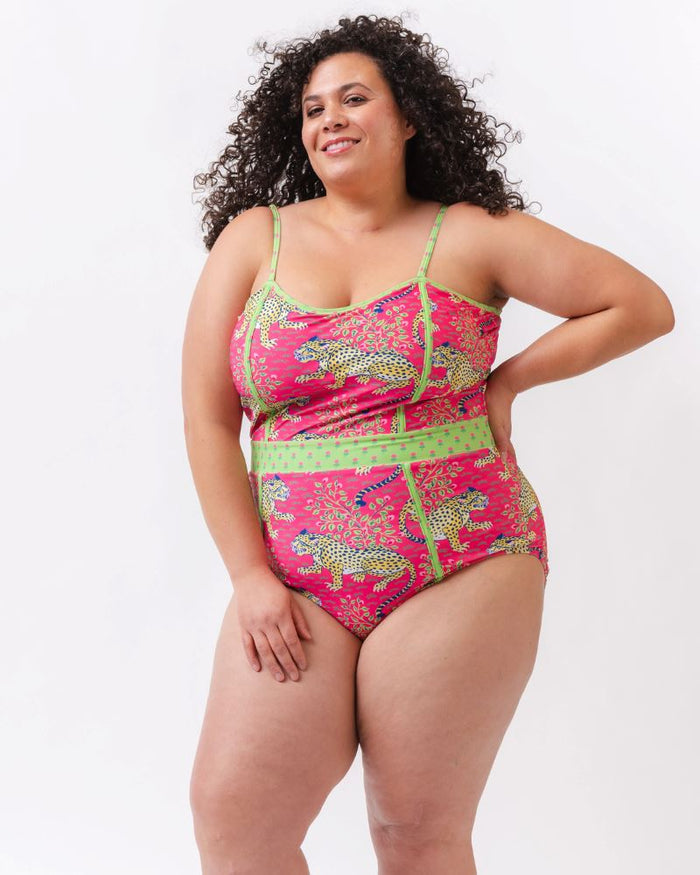 Photo of a woman wearing a bold pink and green print featuring tigers classic one-piece swim suit