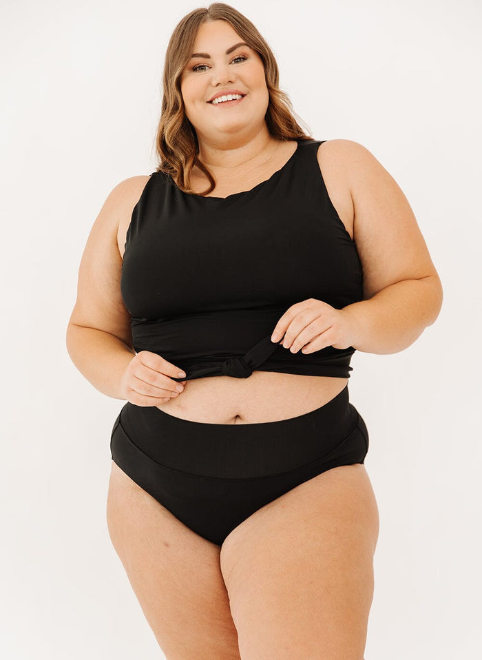 Photo of a woman in a black classic swim bottoms and black knotted swim crop top