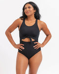 Woman wearing a black knotted one piece swimsuit with a white background