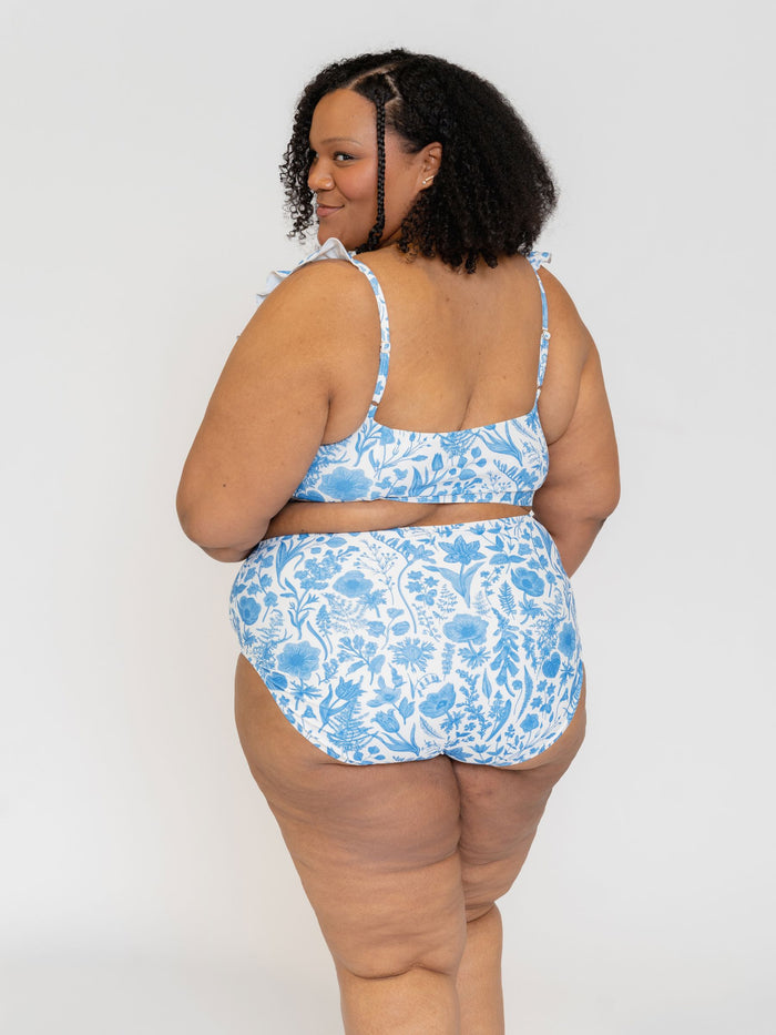 Back View of a Woman wearing a blue floral bikini set on a white background