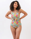 Photo of a woman wearing a multi colored floral knotted one piece swim suit