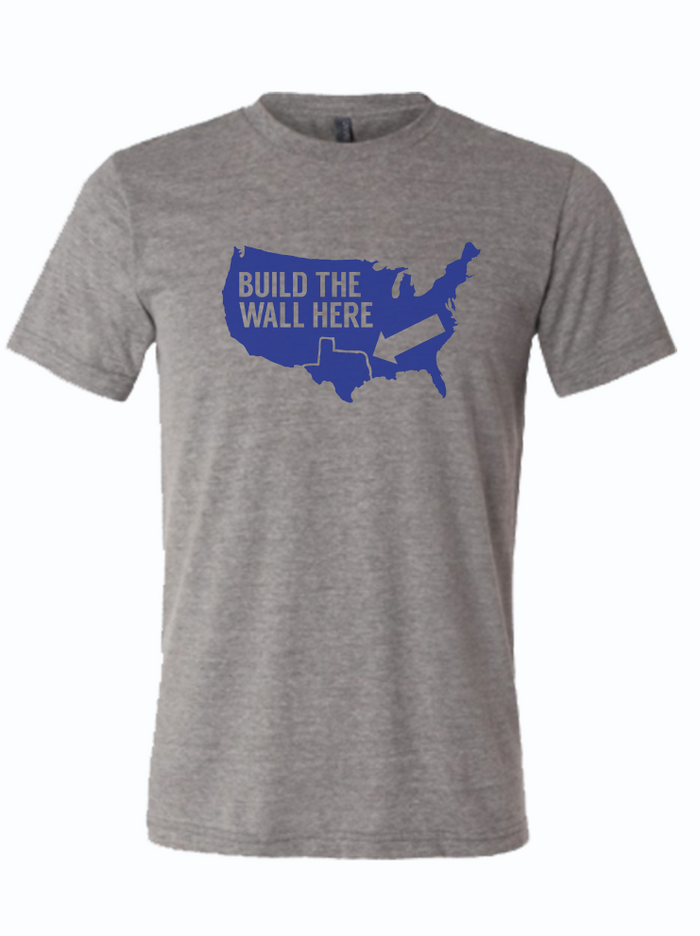 Gray tshirt with a graphic of the united states and text reading "build the wall here" with an arrow pointing to a line above Texas.
