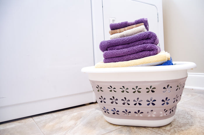Camco Collapsible Laundry Basket Holding Folded Towels Near Washer - Lifestyle Scene | United RV Parts