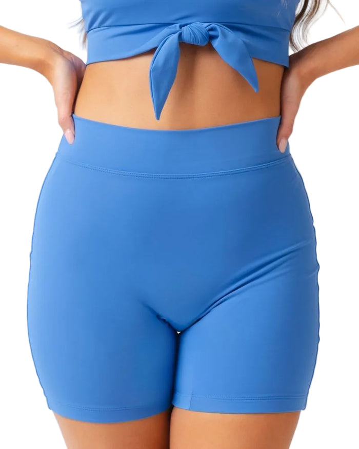 Person wearing blue athletic shorts and top on a white background