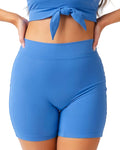 Person wearing blue athletic shorts and top on a white background