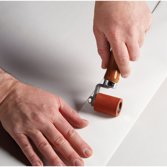 Roller Tool Pressing White RV Roof Repair Tape onto Surface - Application Detail | United RV Parts