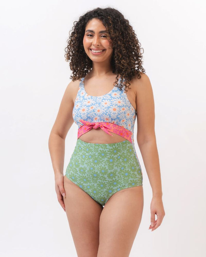 Photo of a woman wearing a blue and green floral knotted one piece swim suit