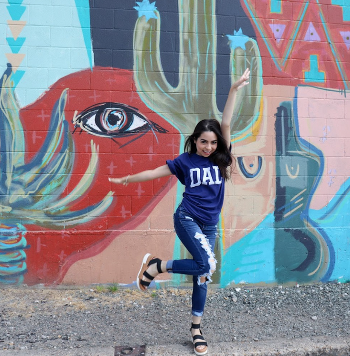 Photo of a woman wearing the Bullzerk DAL Navy tshirt and jumping in the air laughing.