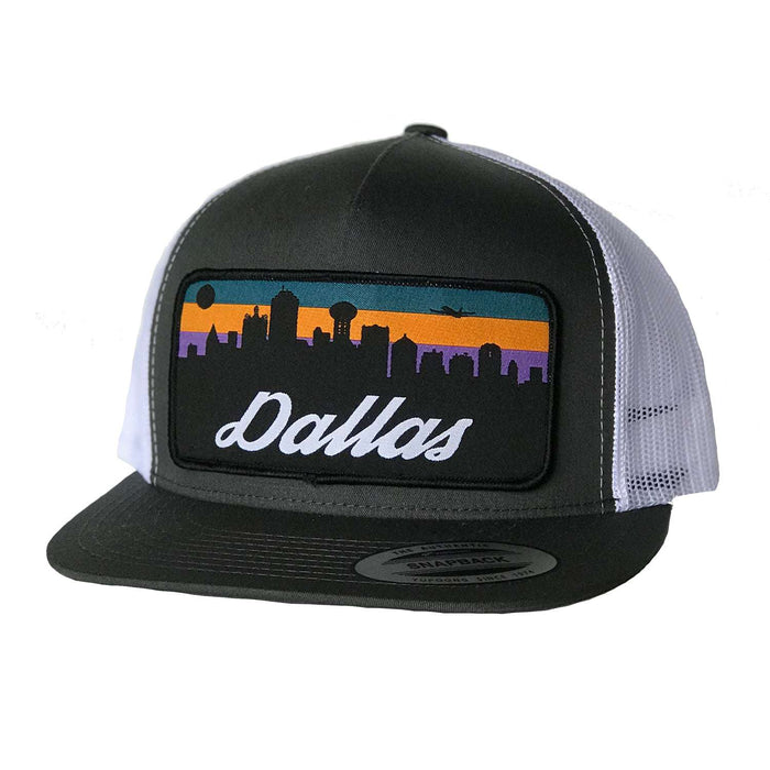 Side view of the Dallas Skyline Patched Flat Bill Hat showcasing the colorful embroidered patch in a black and white color scheme. An ideal choice for those seeking Texas Made Gifts or a memorable dallas souvenir to celebrate Texan culture.