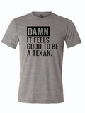 Gray tshirt with text design reading 'Damn it feels good to be a texan" in black letters.