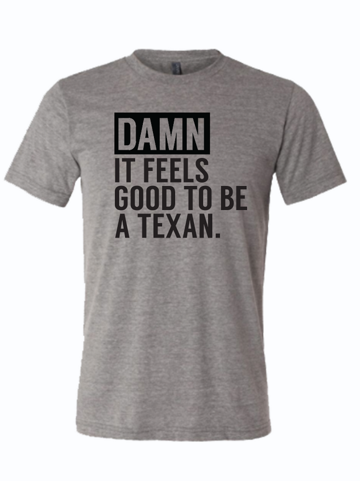 Gray tshirt with text design reading 'Damn it feels good to be a texan" in black letters.