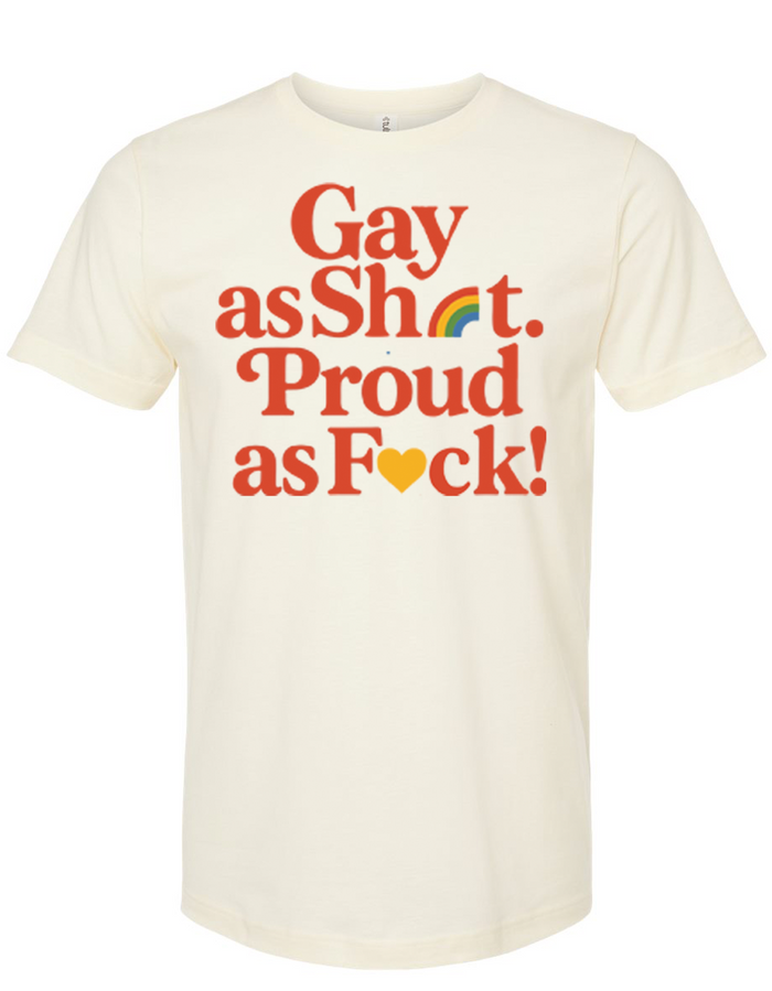 A cream-colored T-shirt featuring the bold text 'Gay as Sh*t. Proud as F*ck!' with a rainbow icon, perfect for showcasing pride. This shirt makes for a great Texas themed gift and is among stylish Texas Made Gifts, ideal as souvenirs from Texas, especially as a Dallas souvenir or a unique Texan gift.