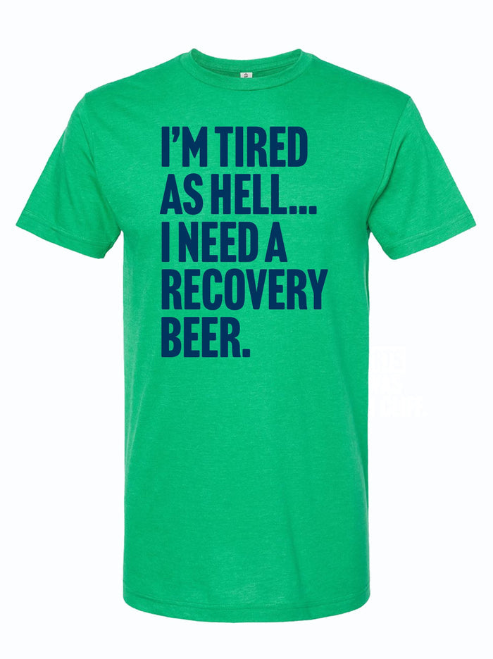 Green unisex fine jersey tee with the quote 'I’m Tired As Hell... I Need A Recovery Beer.' This shirt makes a perfect Texas themed gift, ideal for anyone looking for Texas Made Gifts, unique souvenirs from Texas, a fun Dallas souvenir, or great Texan gifts.