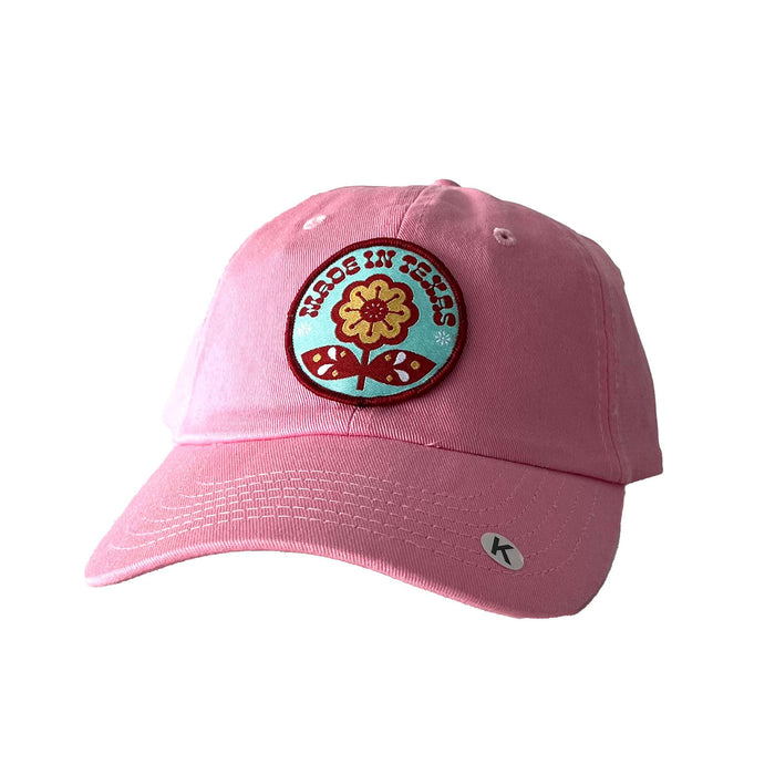 Kids - Made in Tx Flower Pink Cotton Hat featuring a vibrant flower patch, perfect as a Texas themed gift. Made for youth, this hat is an ideal Texas Made Gift for little ones, a great souvenir from Texas, and a charming Dallas souvenir for kids who love Texan gifts.