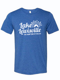 A royal blue shirt that reads "Lake Lewisville the Hamptons of Dallas" in white ink. Features a graphic of a sun over waves.