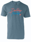 Slate blue tshirt with graphic design of text reading "Dallas Texas" in a thin script font in pink and blue letters.