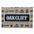 A stylish Oak Cliff Patch featuring bold white lettering on a black background, perfect for decorating jackets or bags. This Texas themed gift showcases quality embroidery and iron-on backing, making it an ideal souvenir from Texas, a great find among Dallas souvenirs and Texan gifts.