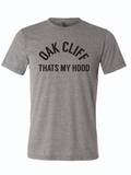 Gray tshirt with text design reading "Oak cliff That's my hood" in black letters.