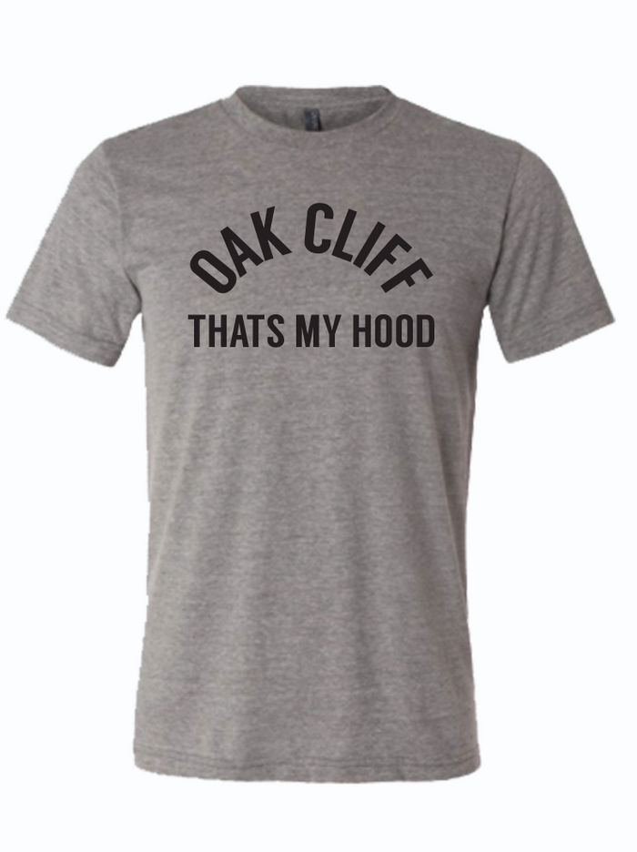 Gray tshirt with text design reading "Oak cliff That's my hood" in black letters.