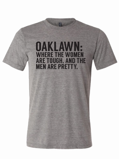 Oak Lawn: Where The Women Are Tough And The Men Are Pretty t-shirt featuring bold text on a comfortable light gray fabric. This stylish tee makes a perfect Texas themed gift, ideal as Texas Made Gifts and souvenirs from Texas, especially for those seeking a unique Dallas souvenir or Texan gifts.