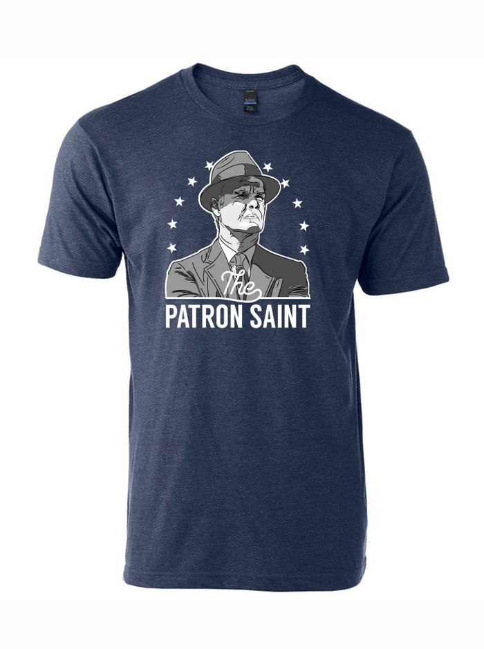 Denim blue tshirt with graphic design of Tom Landry in a circle of stars and text underneath reading "The Patron Saint" in white text.