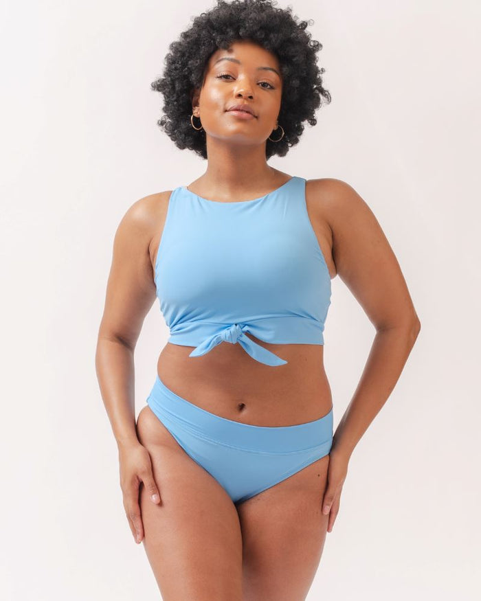 Photo of a woman wearing a light periwinkle blue classic swim bottom with a light periwinkle blue swim crop top