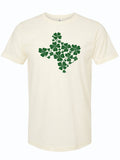 Cream tshirt with graphic design of the shape of Texas filled with green shamrocks.