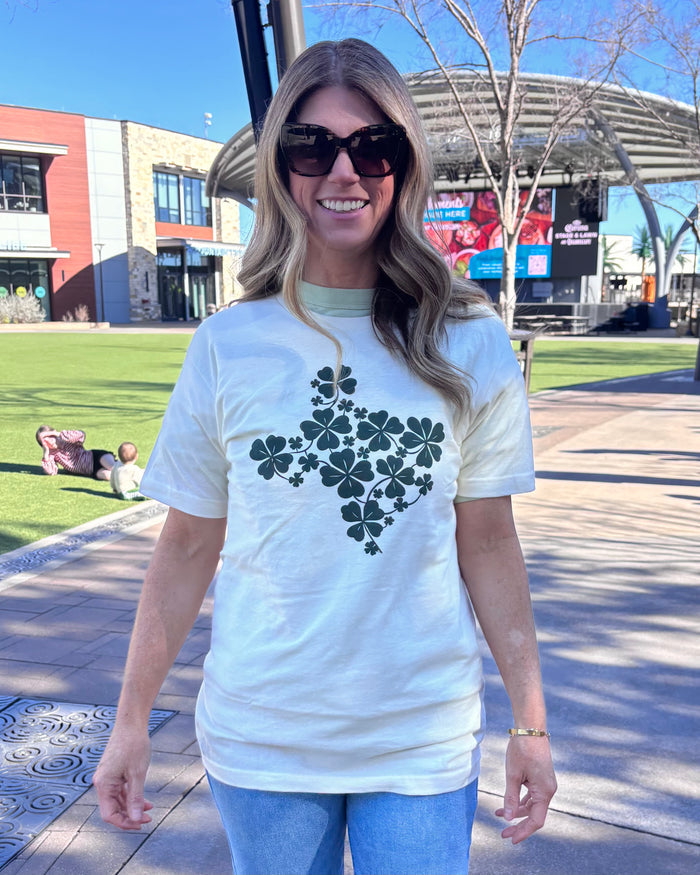 Woman wearing a Bullzerk "Shamrocks Texas" t-shirt and sunglasses, walking outdoors.