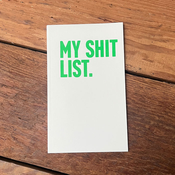 Shit List Notebook featuring bold green lettering on a white cover, perfect as a Texas themed gift for those who love unique stationery. This stylish notebook, a souvenir from Texas, is ideal for jotting down thoughts and ideas, making it a great addition to any Dallas souvenir collection or as a thoughtful Texan gift.