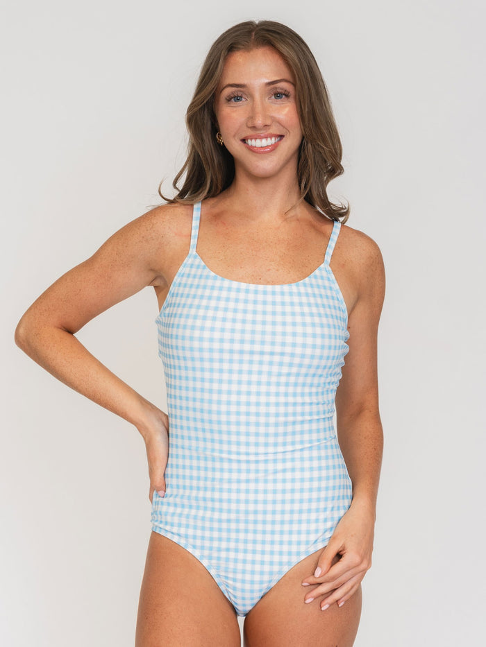 Woman wearing a blue and white checkered swimsuit against a plain background