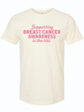 A unisex fine jersey tee in cream color featuring the text 'Supporting Breast Cancer Awareness is the tits.' This stylish shirt is a great Texas themed gift, perfect for raising awareness and making a statement. A fantastic choice among Texas Made Gifts and ideal souvenirs from Texas, this shirt also makes for a unique Dallas souvenir or a special treat in the realm of Texan gifts.