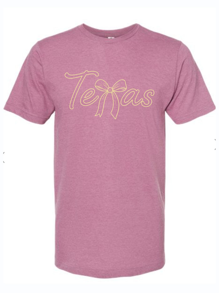 Mauve pink tshirt with graphic design of the word Texas with the letter X Made out of a ribbon bow.