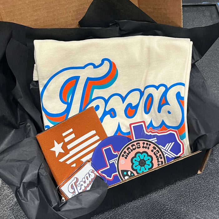 A Texas Gift Box featuring a Bullzerk Texas Script t-shirt and an assortment of Texas-themed small products.