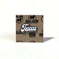 Texas Script Enamel Pin displayed on kraft paper backing, showcasing a vibrant design perfect for Texas themed gift, Texas Made Gifts, and souvenirs from Texas, ideal for anyone looking for a Dallas souvenir or Texan gifts.