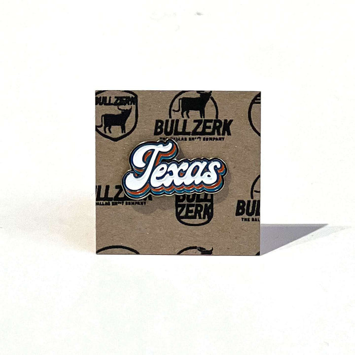 Texas Script Enamel Pin displayed on kraft paper backing, showcasing a vibrant design perfect for Texas themed gift, Texas Made Gifts, and souvenirs from Texas, ideal for anyone looking for a Dallas souvenir or Texan gifts.
