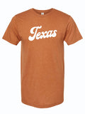 Rust orange tshirt with a graphic design of TEXAS written in a white, bubble lettered script font.