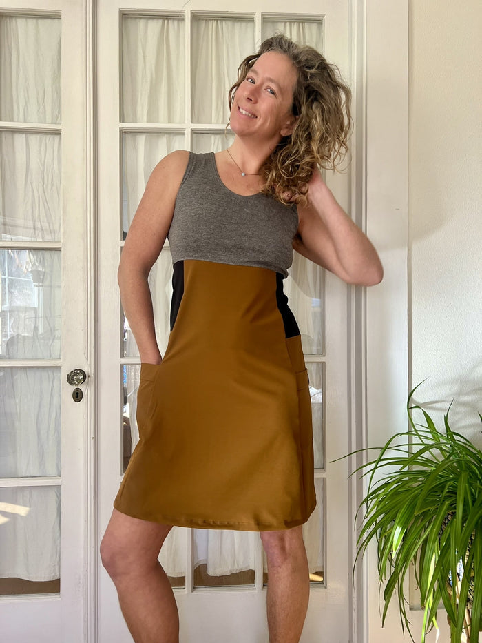 Person wearing a copper dress standing in front of a glass door.
