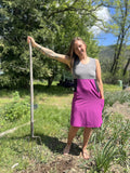 Person standing outdoors wearing a magenta dress