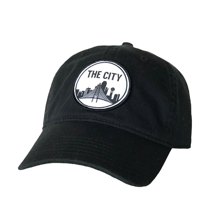 The City Patched Cotton Hat in black, featuring a stylish embroidered patch, perfect for showcasing Texas pride. This hat makes a great Texas themed gift, ideal for anyone looking for Texas Made Gifts and authentic souvenirs from Texas, especially Dallas souvenirs and Texan gifts.
