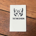 The Time Is Meow Notebook featuring a cute cat design, perfect for note-taking or journaling. This Texas themed gift is a great choice for anyone looking for Texas Made Gifts or souvenirs from Texas. Ideal as a Dallas souvenir or unique Texan gifts to celebrate creativity.