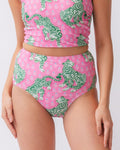 Close up photo of a woman wearing a bold pink and green tiger print high waist swim bottom