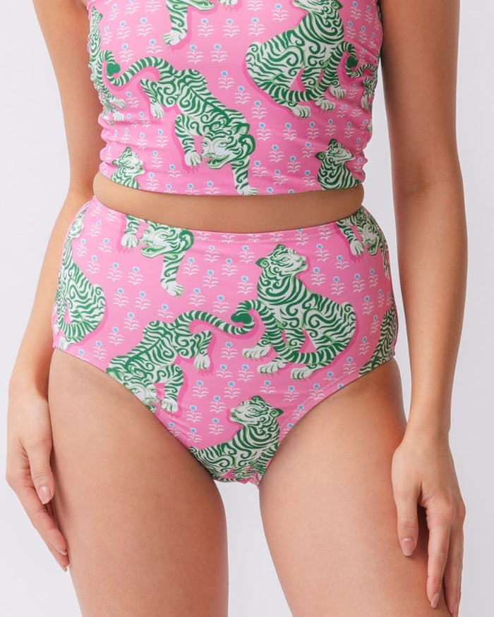 Close up photo of a woman wearing a bold pink and green tiger print high waist swim bottom