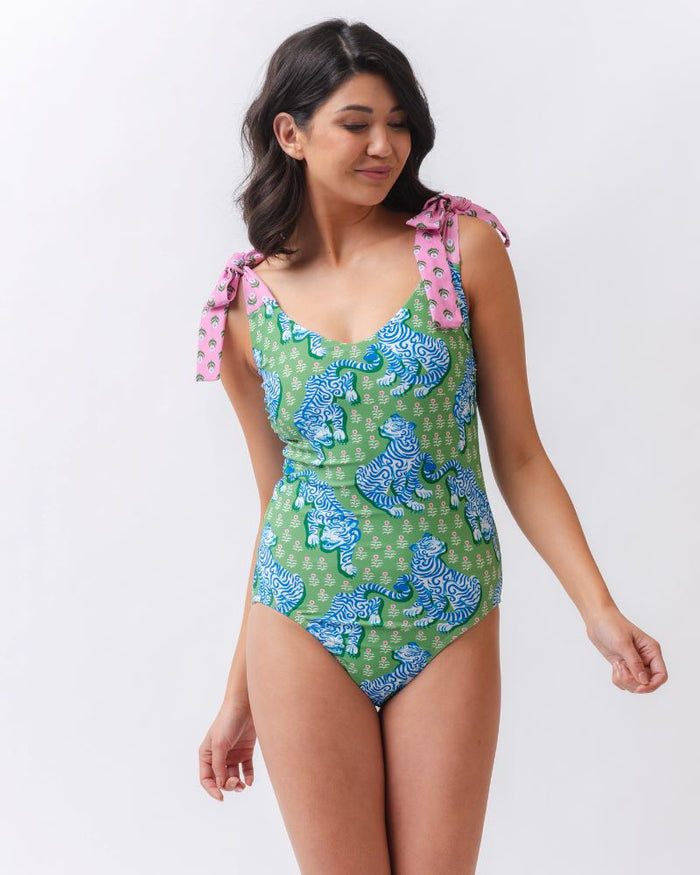 Photo of a woman wearing a bold green and pink tiger print shoulder tie swim one piece
