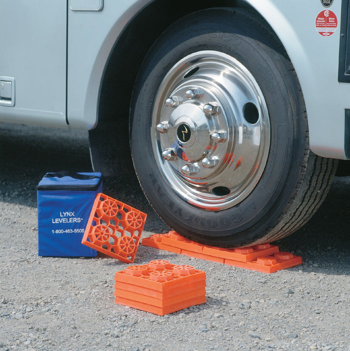 Orange RV Leveling Blocks with Blue Storage Bag Under Motorhome Wheel | United RV Parts