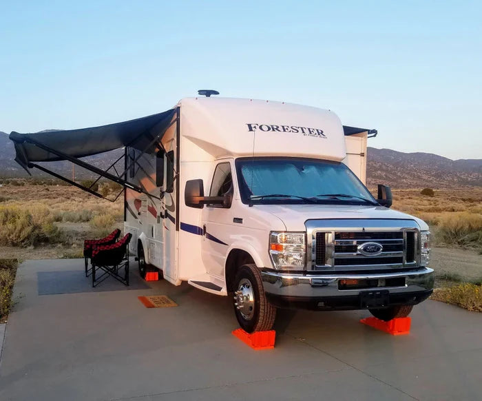 White Class C RV with Orange Wheel Chocks - Desert Camping Setup | United RV Parts