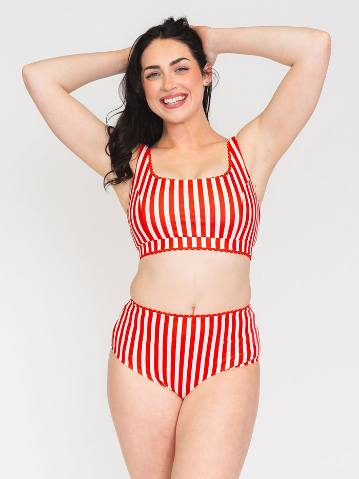 Woman wearing a red and white striped bikini set on a white background